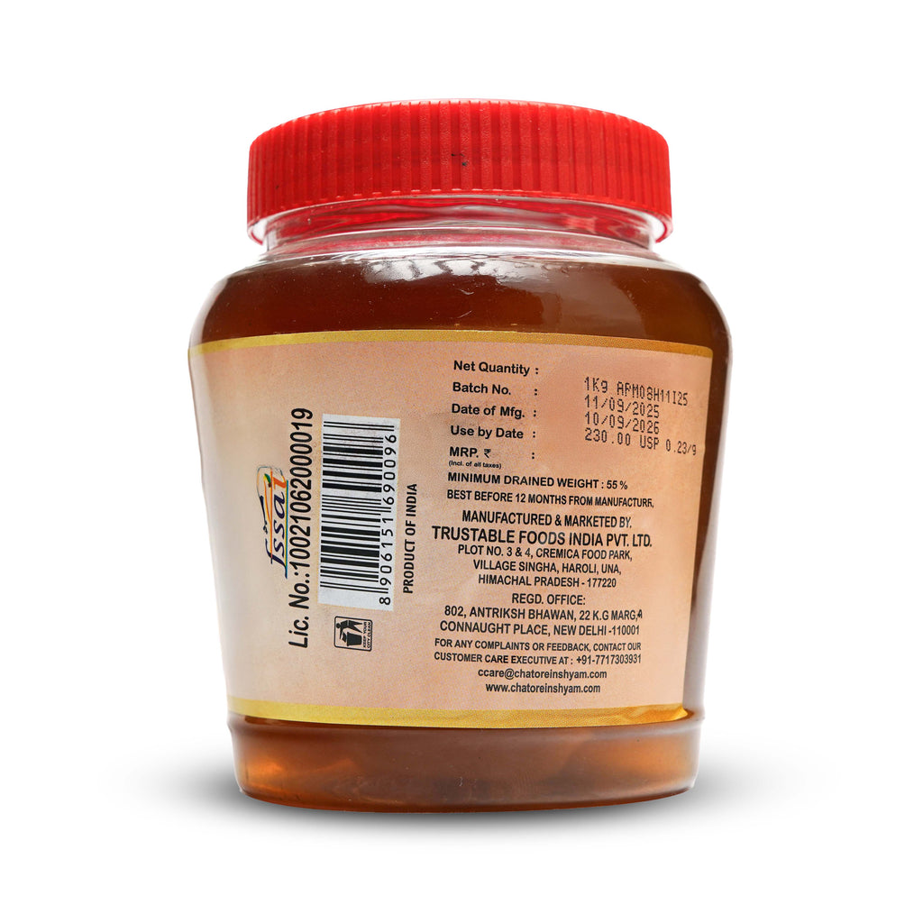 Jar of honey with a red lid on a white background