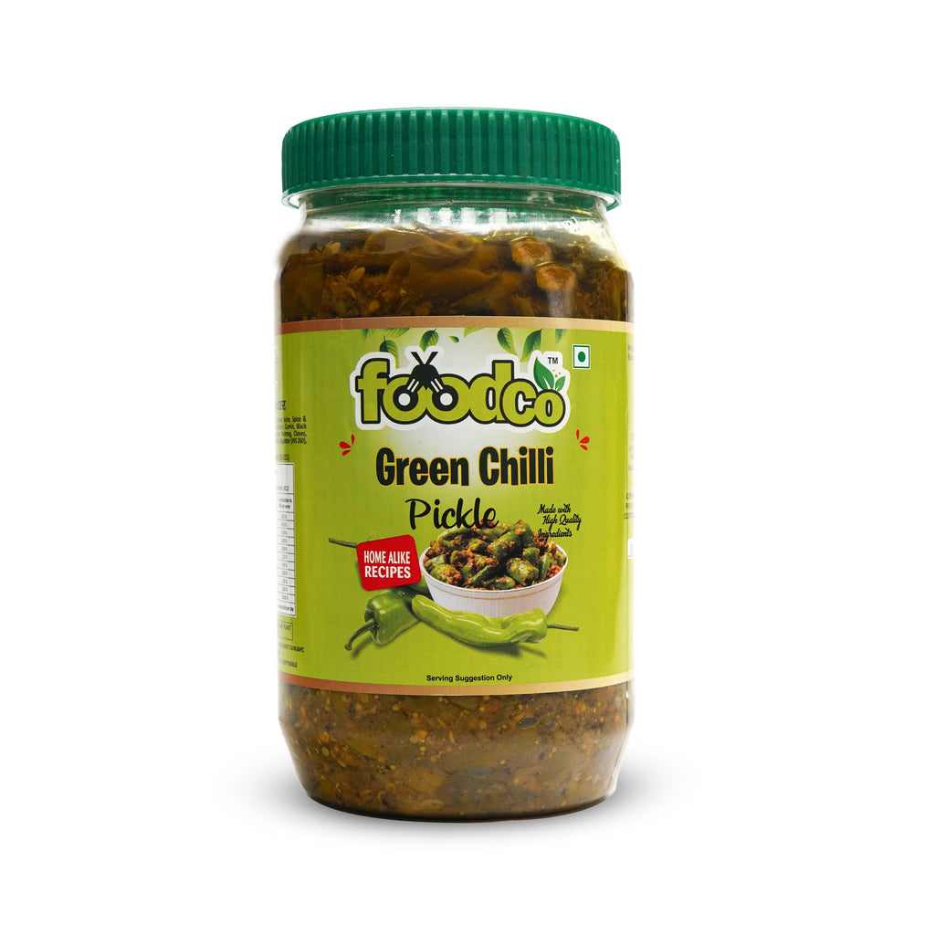 Jar of green chili pickle with a green lid on a white background