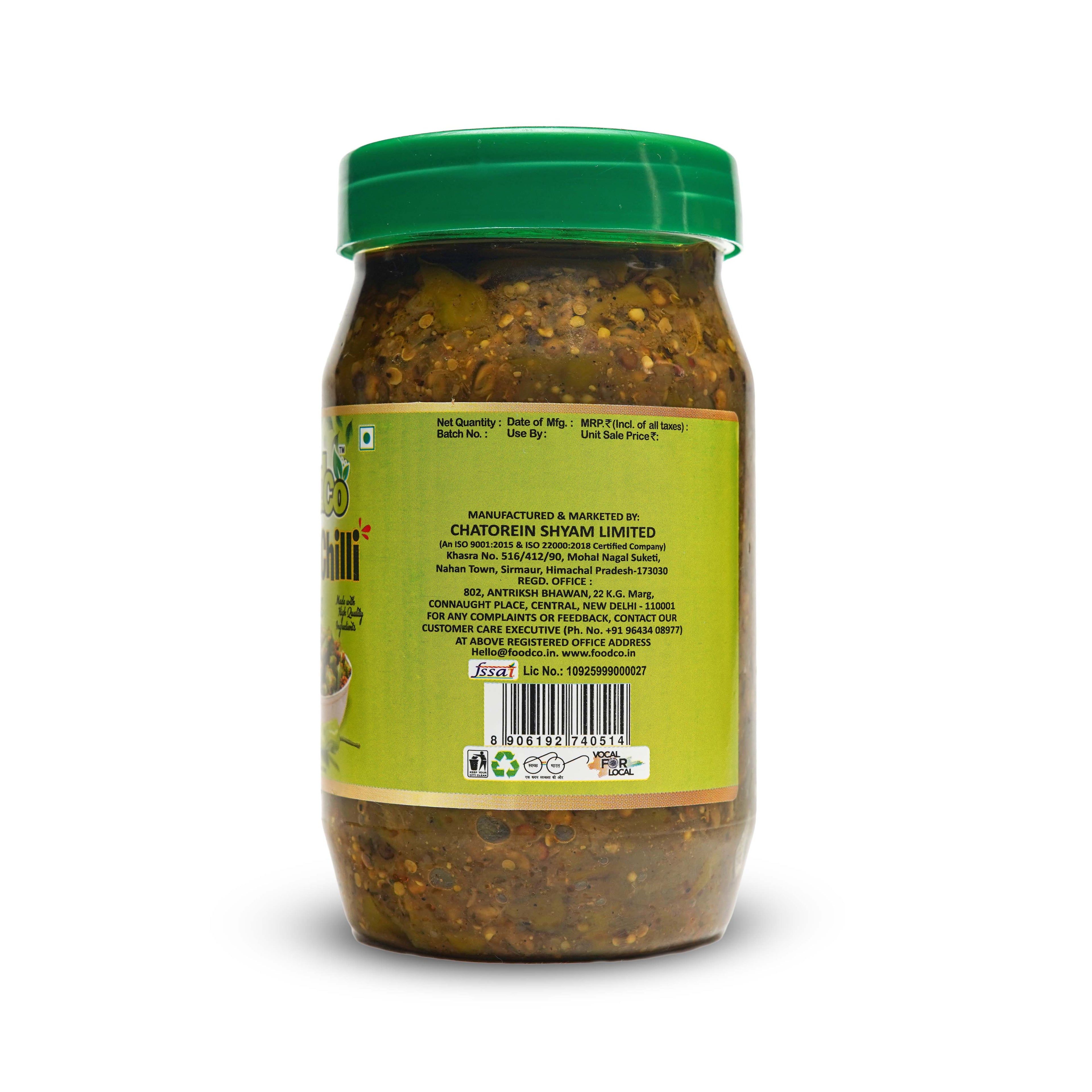 Jar of green chutney with a green lid on a white background